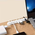 White Silicone Cable Holder with 7 slots organizing USB cords on a wooden desk