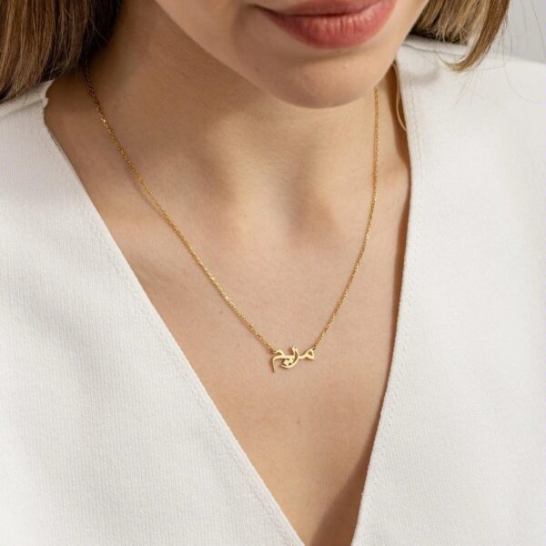 Copper necklace pendant spelling the name Mariam in Arabic calligraphy