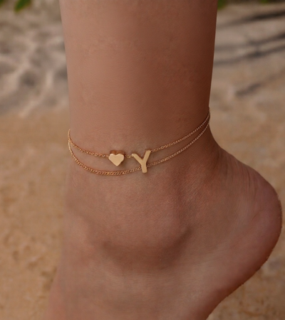 Woman wearing a Letter Y Heart Anklet with a double-layer chain and heart charm