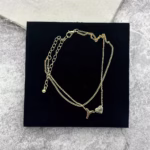 Woman wearing a Letter Y Heart Anklet with a double-layer chain and heart charm