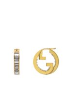 Close-up of Gucci Blondie light gold-toned hoop earrings with crystal embellishments.