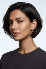 A close-up of Asia with Valentino Garavani VLogo earrings in gold-tone metal with rhinestones