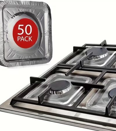 Hand holding a silver disposable square aluminum stove burner cover with a round center hole.