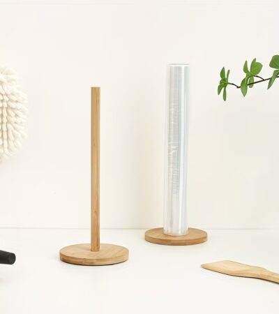 A standing light-colored wooden paper towel holder standing on a kitchen counter.