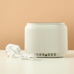 Black electric aroma diffuser with orange LED flame-effect mist.