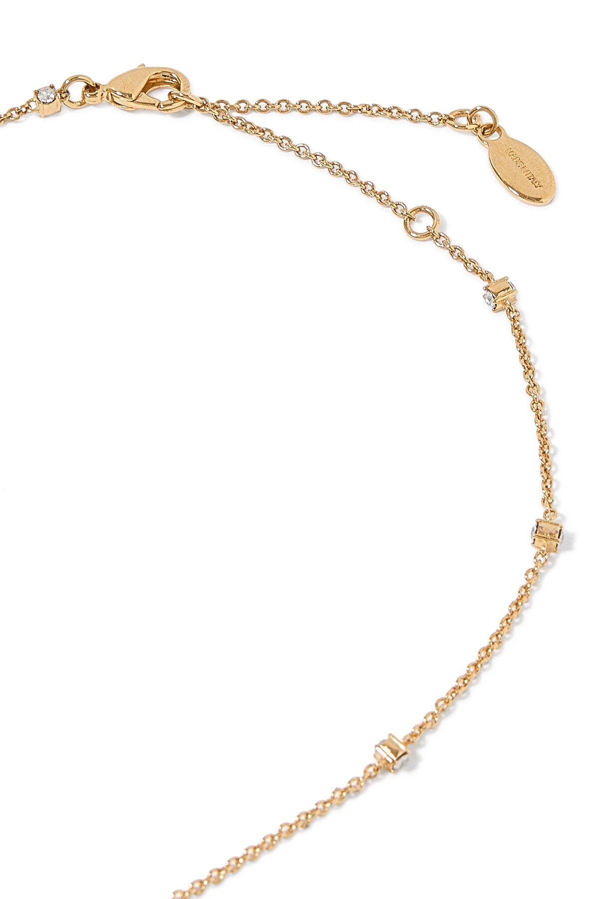 Close-up of Valentino Garavani Mini VLogo pendant with Swarovski crystals on a metal chain.