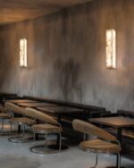 Leldashti waterproof LED wall light with an iron finish and copper accents is mounted on a modern wall.