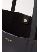 Saint Laurent East/West black leather tote bag with gold YSL charm and detachable pouch.