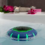 Blue and black InnovaGoods floating wireless speaker floating in a swimming pool