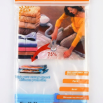 A transparent 60x80cm vacuum storage bag containing a folded blue quilt being compressed by a vacuum cleaner nozzle.