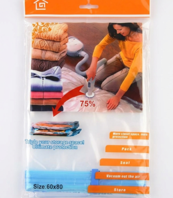 A transparent 60x80cm vacuum storage bag containing a folded blue quilt being compressed by a vacuum cleaner nozzle.