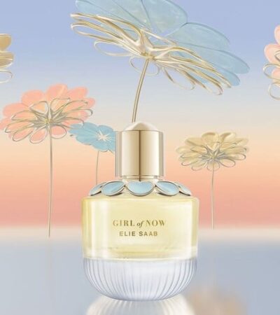 The elegant glass bottle of Elie Saab Girl of Now EDP featuring blue flower petal embellishments.
