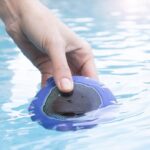 Blue and black InnovaGoods floating wireless speaker floating in a swimming pool