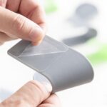 Set of three green and grey adhesive holders for saucepan lids.