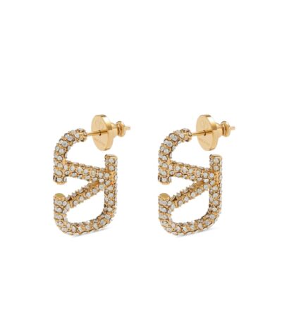 Elevate your style and make a lasting impression with the Valentino Garavani VLogo Signature Earrings, exquisitely crafted in radiant polished gold. These designer earrings blend contemporary elegance with timeless sophistication, featuring the iconic VLogo motif that embodies the luxury and heritage of Valentino. Perfectly suited for both everyday chic ensembles and glamorous evening occasions, they add a refined touch to any outfit while reflecting impeccable taste and fashion-forward sensibility. Lightweight yet striking, these earrings ensure comfort without compromising on style, making them an essential addition to any luxury jewelry collection.