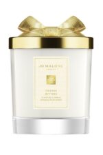 A Jo Malone London Orange Bitters Scented Candle in a limited-edition seasonal jar with a silver lid.
