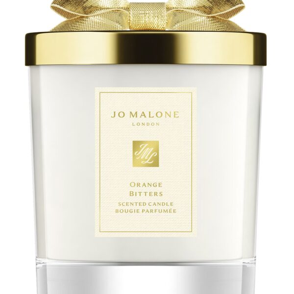 A Jo Malone London Orange Bitters Scented Candle in a limited-edition seasonal jar with a silver lid.