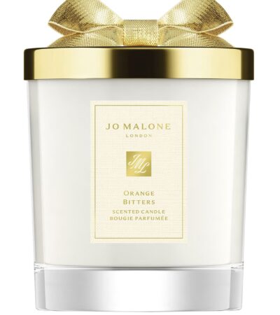 A Jo Malone London Orange Bitters Scented Candle in a limited-edition seasonal jar with a silver lid.