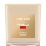 A Tom Ford vanilla-scented candle in a signature vanilla-hued glass jar with a cream label.