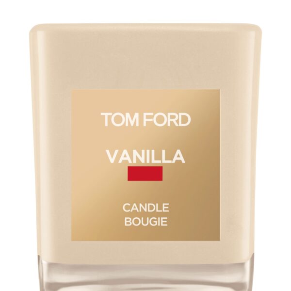 A Tom Ford vanilla-scented candle in a signature vanilla-hued glass jar with a cream label.