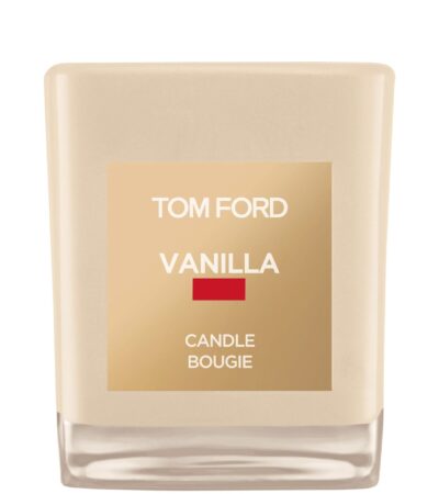 A Tom Ford vanilla-scented candle in a signature vanilla-hued glass jar with a cream label.