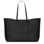 Saint Laurent East/West black leather tote bag with gold YSL charm and detachable pouch.