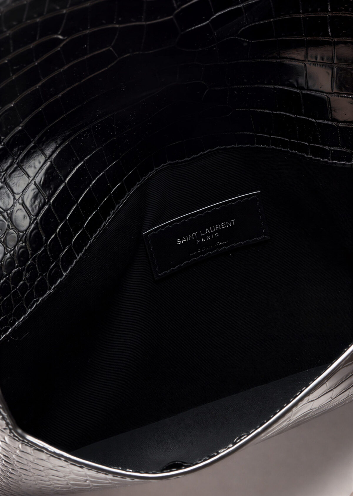 Front view of YSL Uptown Pouch in black crocodile-embossed leather with silver YSL initials