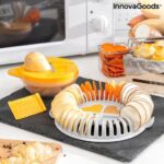 Orange and grey microwave chip maker tray with sliced potatoes and mandolin