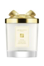 A Jo Malone London Pine & Eucalyptus Scented Candle in a decorative holiday glass jar with a silver lid.