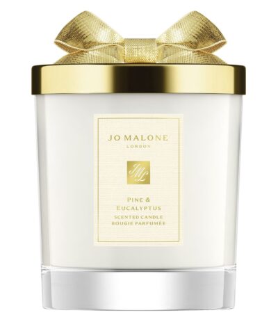 A Jo Malone London Pine & Eucalyptus Scented Candle in a decorative holiday glass jar with a silver lid.