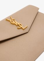 Front view of Saint Laurent Uptown Pouch in black grained leather with gold YSL logo.