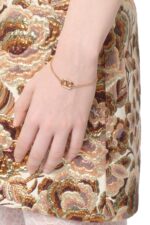 Valentino Garavani Ovalette gold-tone bracelet featuring a Swarovski pearl and VLogo emblem.