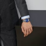 Gucci G-Timeless Slim 40mm automatic watch with blue dial, signature House motifs, and stainless steel bracelet.