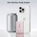 The pink Baseus PicoGo AM31 magnetic power bank attached to a phone using its built-in kickstand.