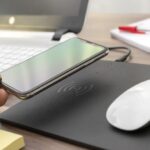 Black leather-style mouse mat with integrated wireless charging zone and smartphone