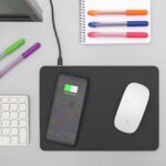 Black leather-style mouse mat with integrated wireless charging zone and smartphone