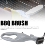 Stainless steel barbeque grill steam brush cleaning a black outdoor grill grate.