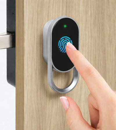 A sleek silver and black smart lock installed on a wooden office drawer.